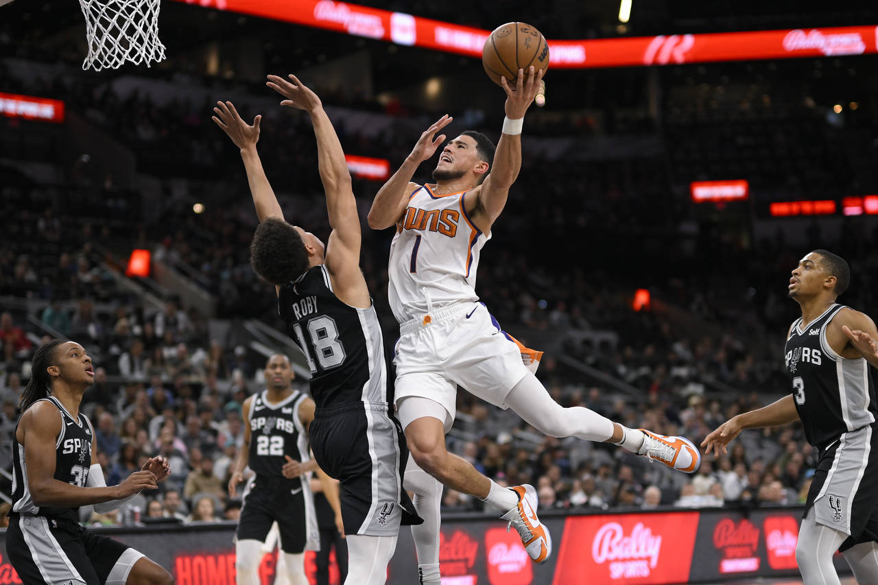 Phoenix Suns' Devin Booker (1) shoots against San Antonio Spurs' Isaiah Roby during the first half ...