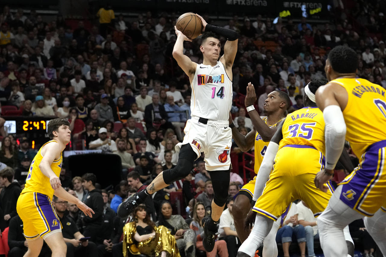 Miami Heat guard Tyler Herro (14) looks to pass as Los Angeles Lakers guard Lonnie Walker IV (4) de...