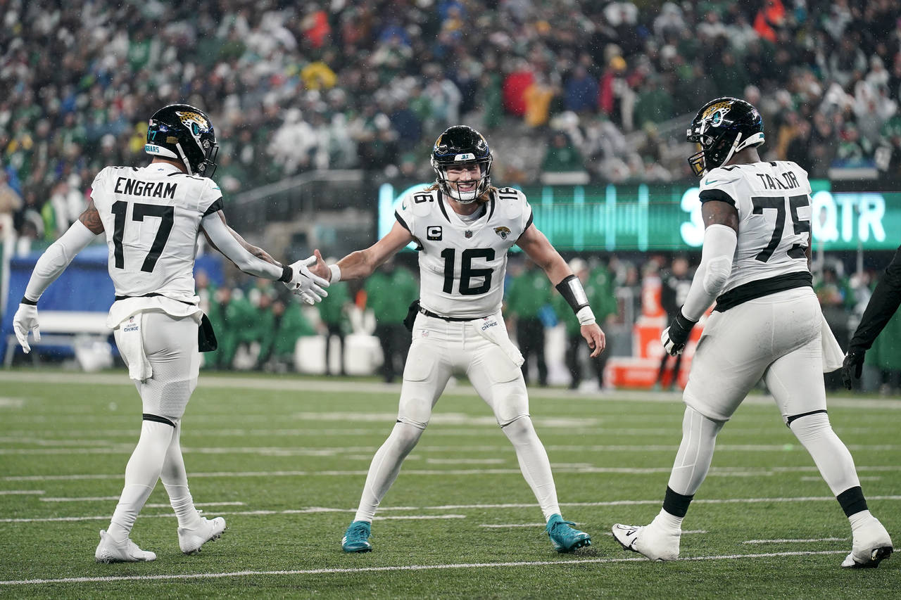 Jacksonville Jaguars quarterback Trevor Lawrence (16) celebrates with tight end Evan Engram (17) an...