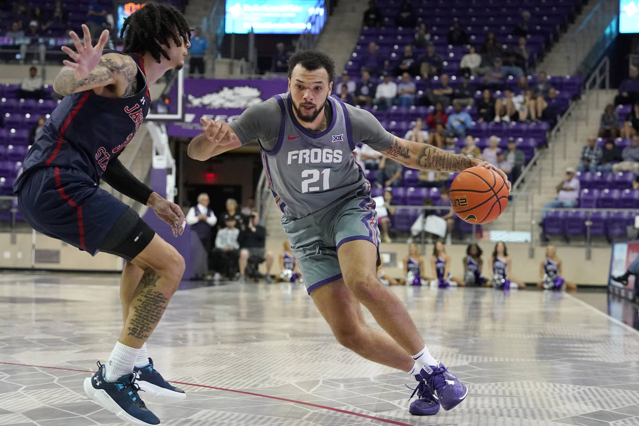 TCU forward JaKobe Coles (21) drives against Jackson State forward Trace Young (3) during the first...