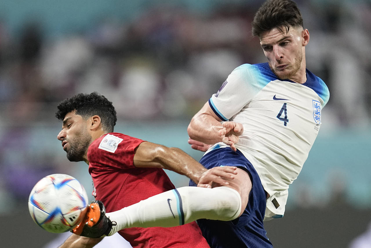 England's Declan Rice, right, kicks the ball past Iran's Mehdi Taremi during the World Cup group B ...