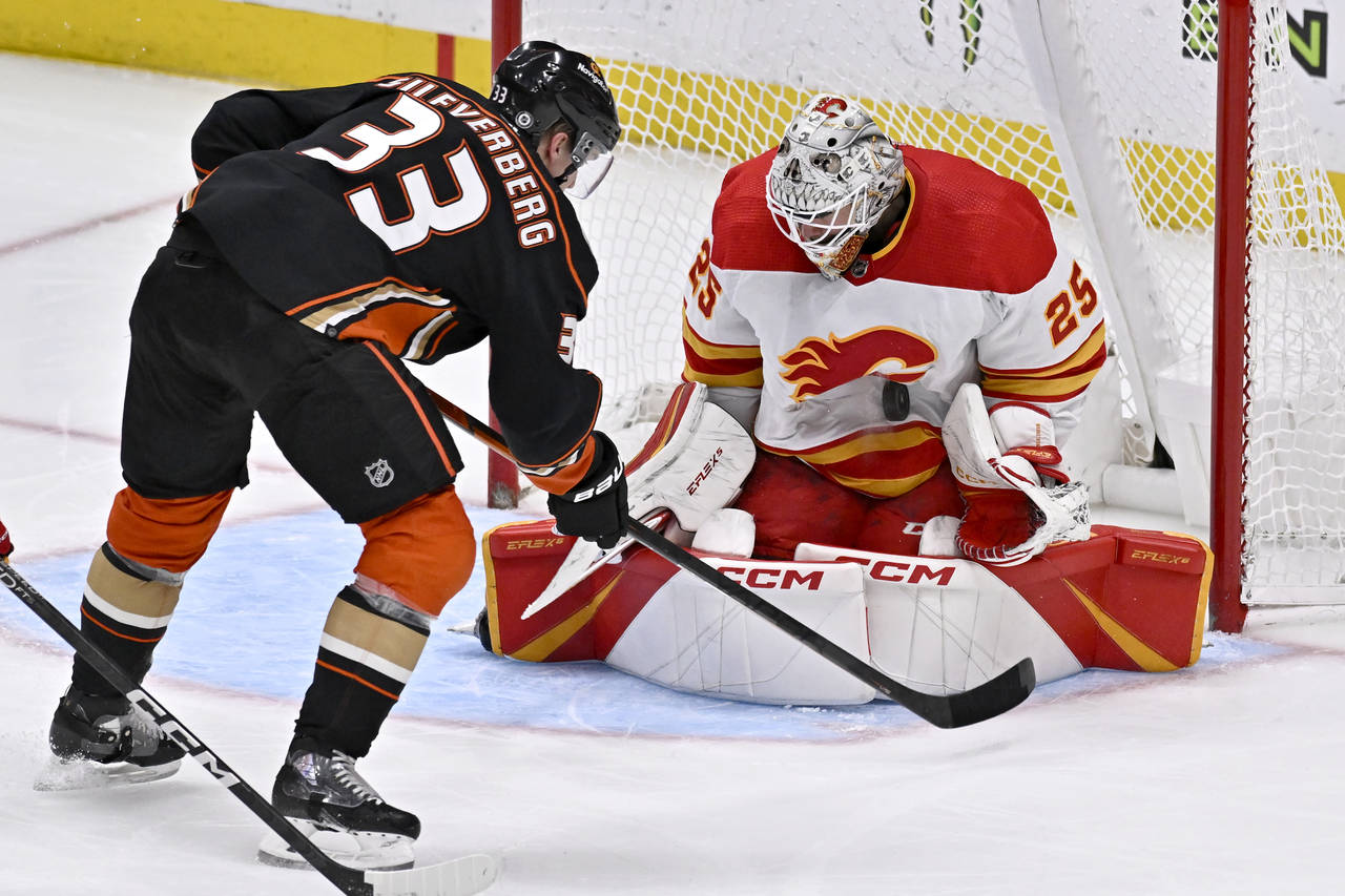 Calgary Flames goaltender Jacob Markstrom, right, stops a shot by Anaheim Ducks right wing Jakob Si...