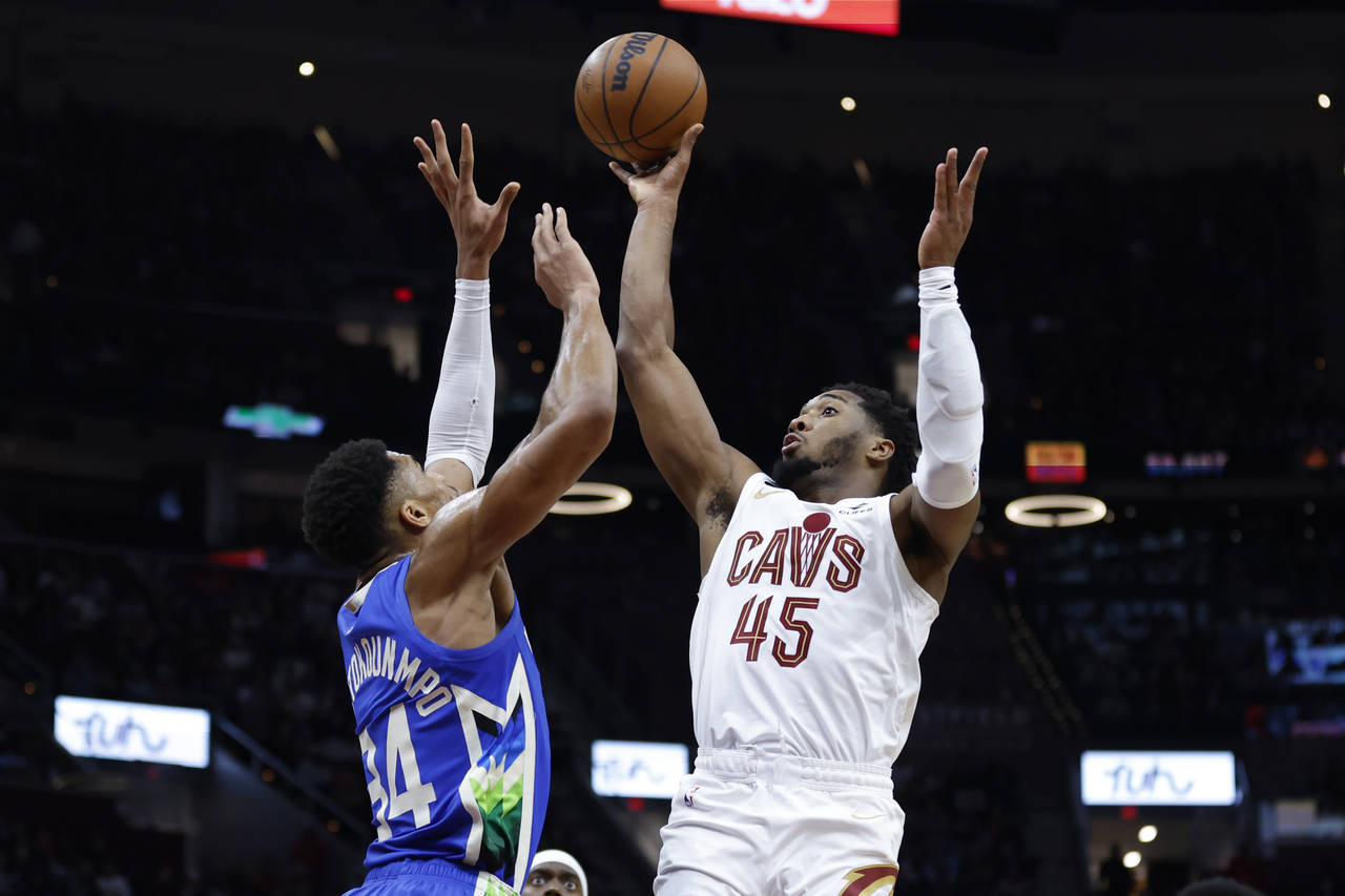 Donovan Mitchell (45), de los Cavaliers de Cleveland, dispara con la marca de Giannis Antetokounmpo...