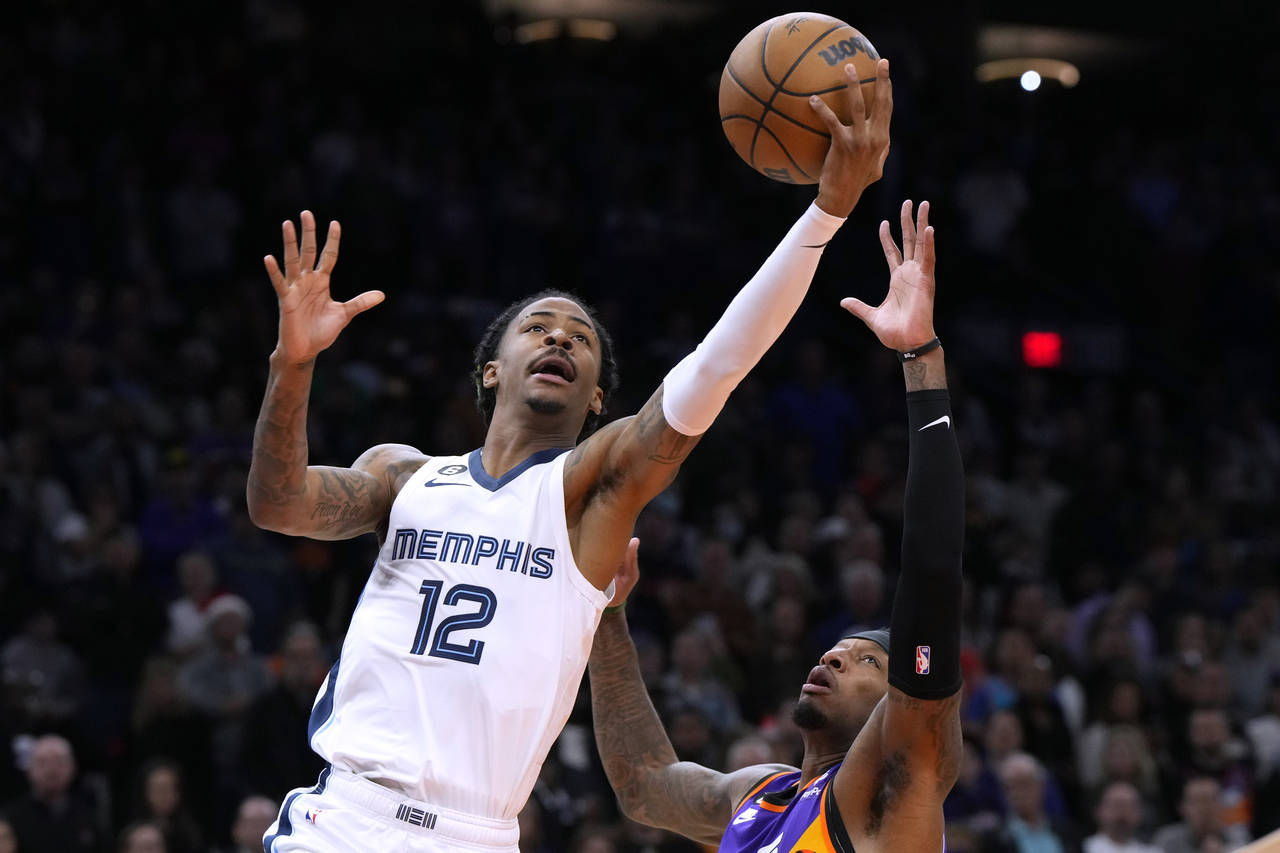 Memphis Grizzlies guard Ja Morant (12) shoots over Phoenix Suns forward Torrey Craig during the fir...