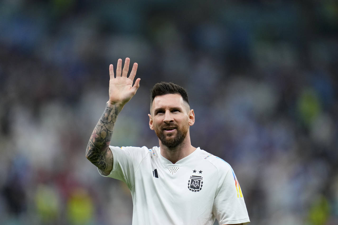 Argentina's Lionel Messi waves during the warm up prior to the World Cup semifinal soccer match bet...