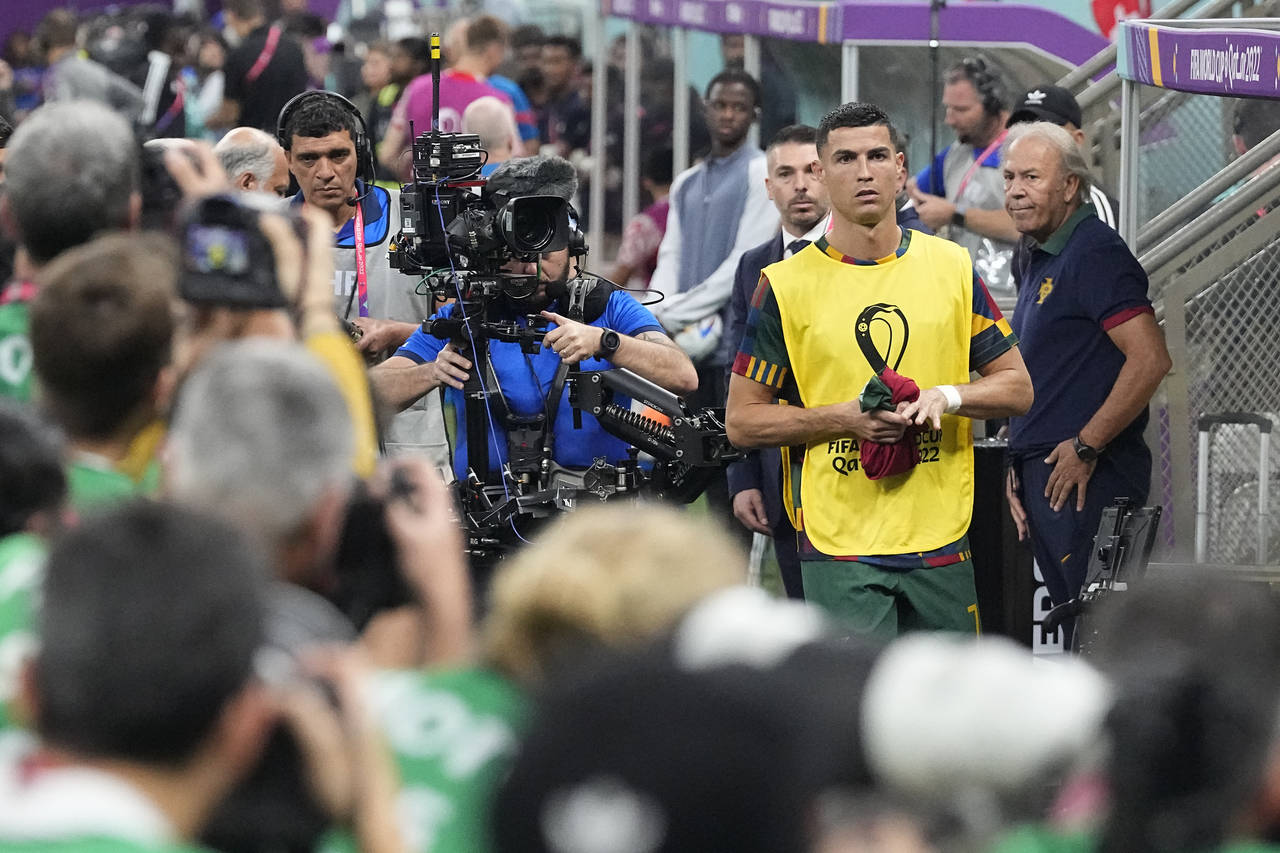 Photographers crowd around as Portugal's Cristiano Ronaldo arrives to take his seat on the bench pr...