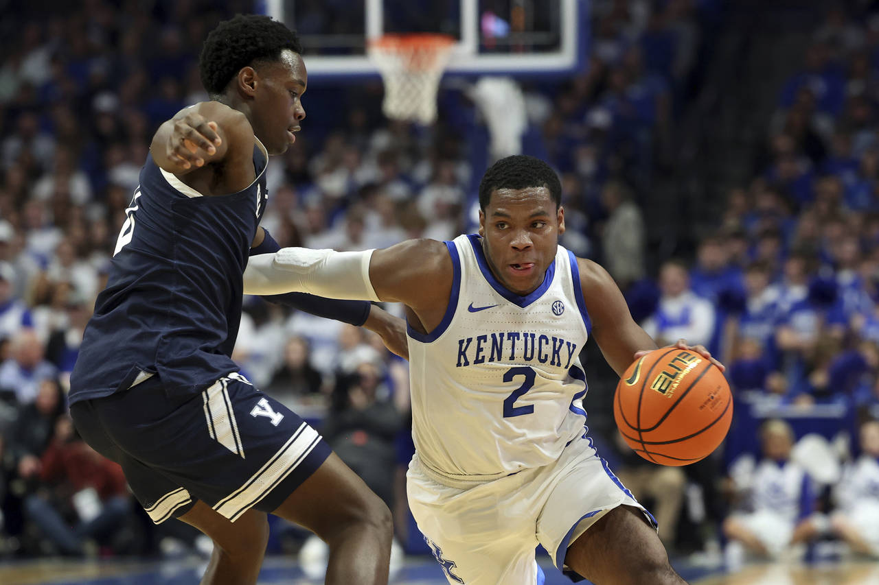 Kentucky's Sahvir Wheeler (2) drives on Yale's Bez Mbeng, left, during the first half of an NCAA co...