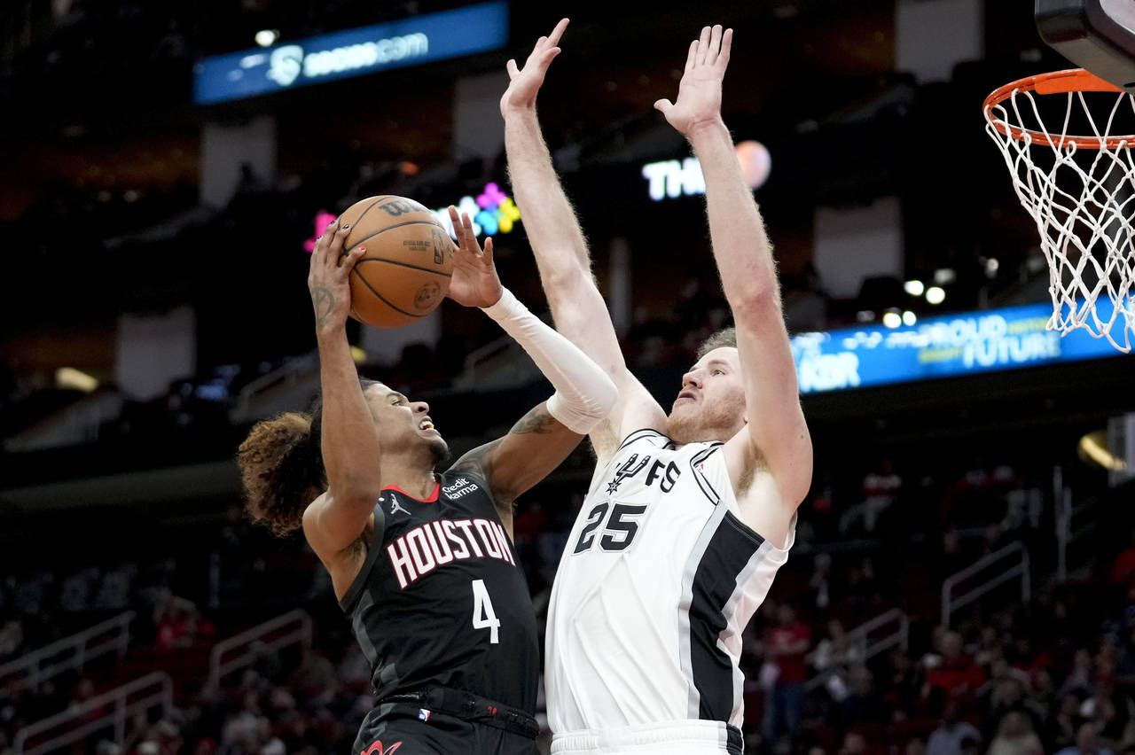 Houston Rockets guard Jalen Green (4) shoots as San Antonio Spurs center Jakob Poeltl defends durin...