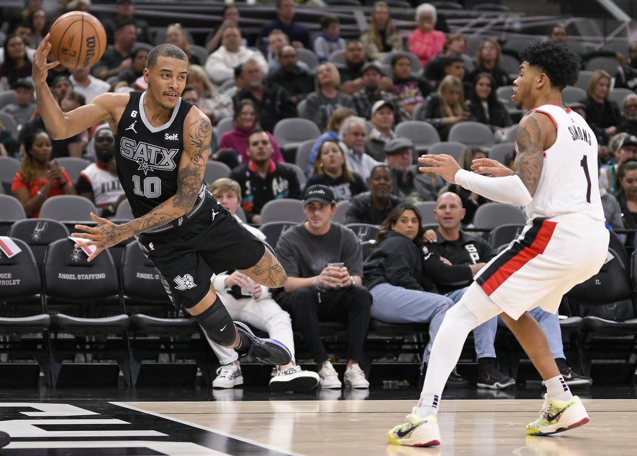 San Antonio Spurs' Jeremy Sochan (10) dives ahead of Portland Trail Blazers' Anfernee Simons to kee...