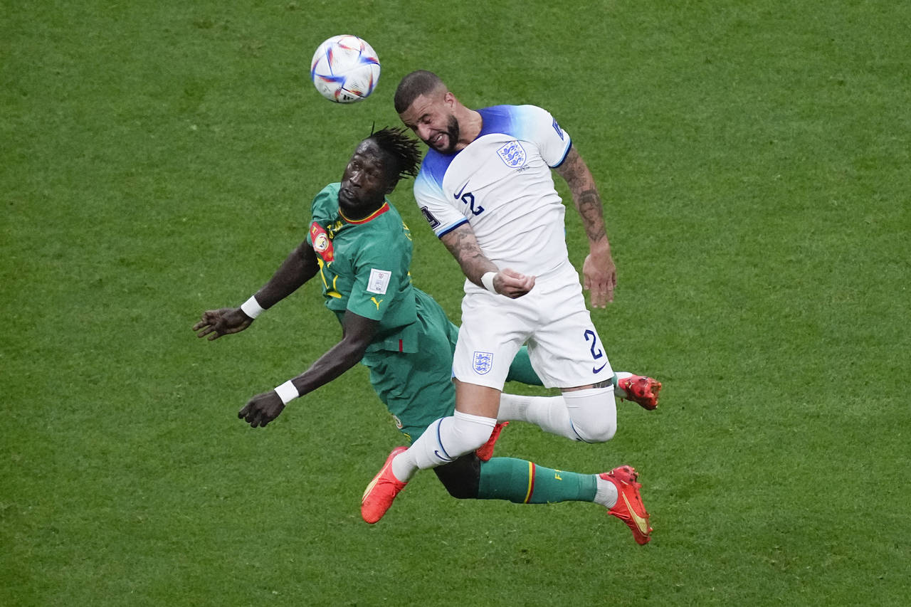 Senegal's Moussa Ndiaye, left, and England's Kyle Walker vie for the ball during the World Cup roun...