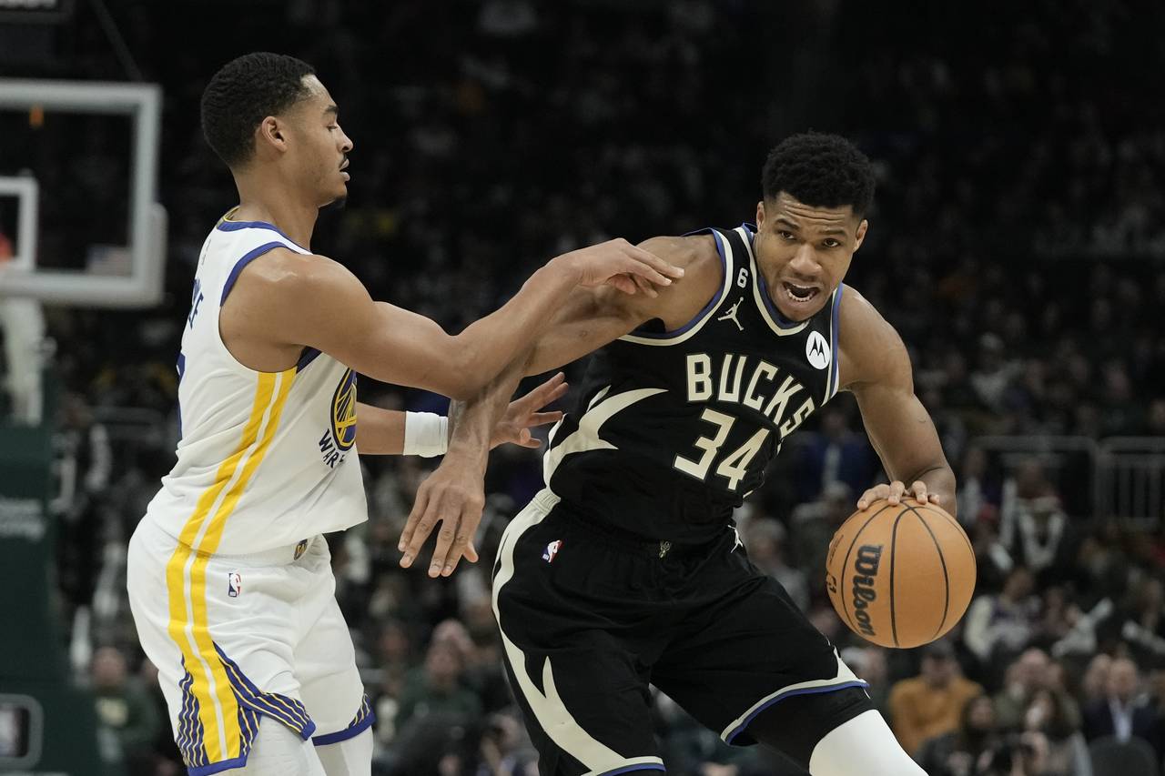 Milwaukee Bucks' Giannis Antetokounmpo is fouled by Golden State Warriors' Jordan Poole during the ...