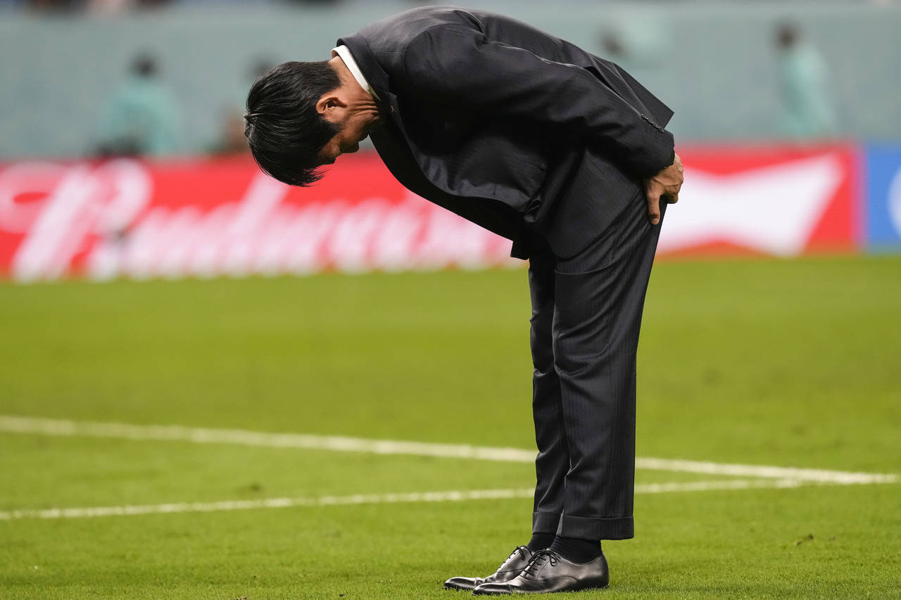 Japan's head coach Hajime Moriyasu bows after losing the penalty shootout of the World Cup round of...