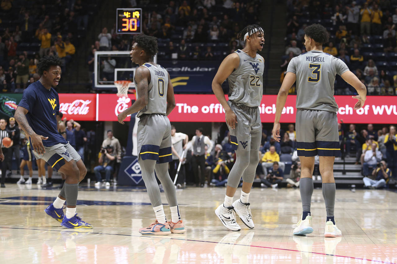 West Virginia players celebrate during the first half of an NCAA college basketball game against UA...