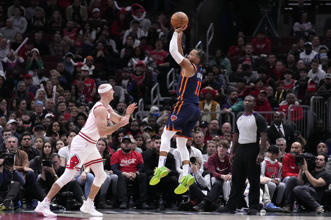 New York Knicks' Jalen Brunson (11) scores as Chicago Bulls' Alex Caruso watches in overtime of an ...