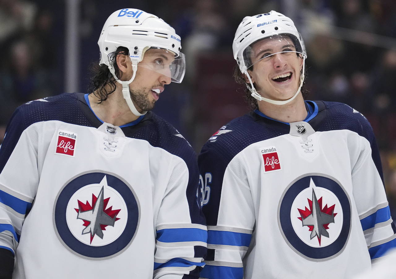 Winnipeg Jets' Brenden Dillon, left, and Morgan Barron talk before a faceoff against the Vancouver ...