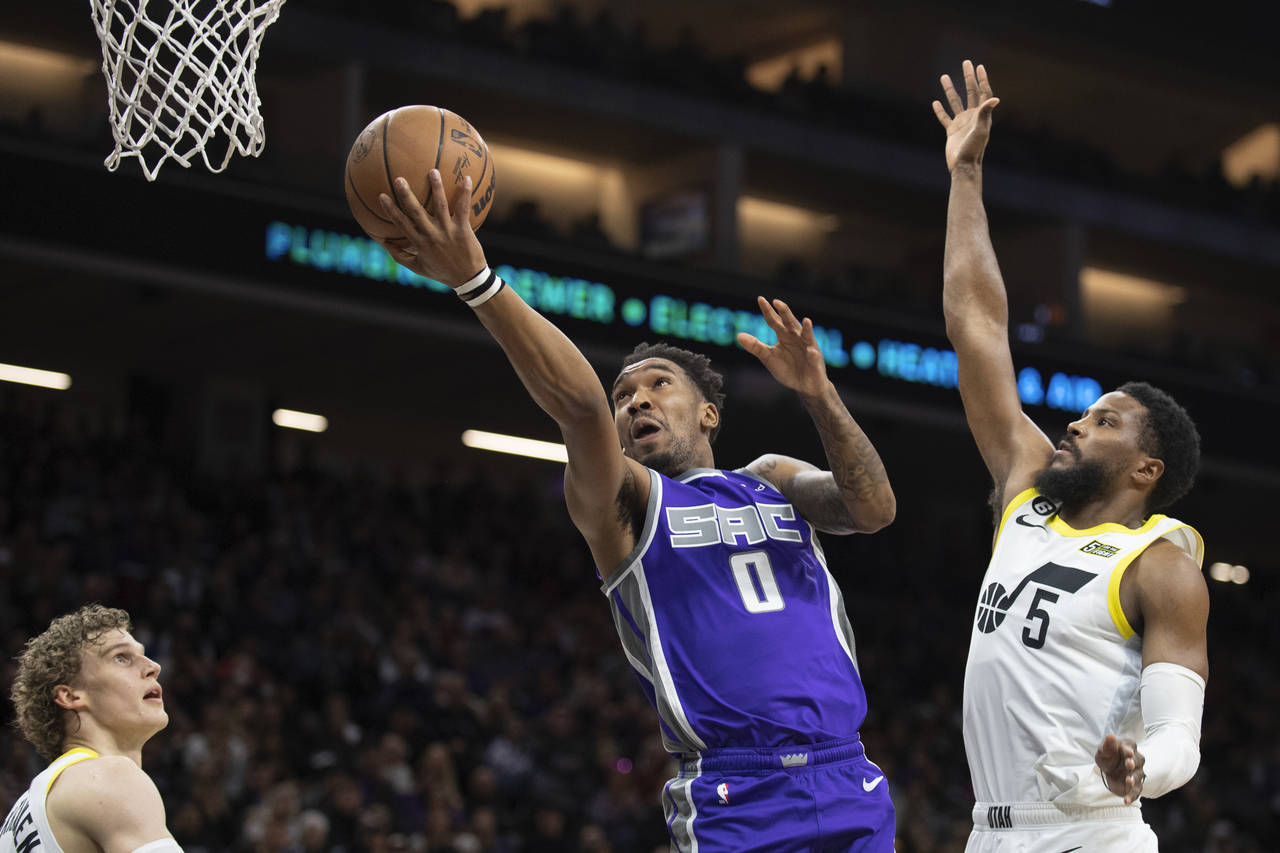 Sacramento Kings guard Malik Monk (0) lays up the ball past Utah Jazz guard Malik Beasley (5) in th...