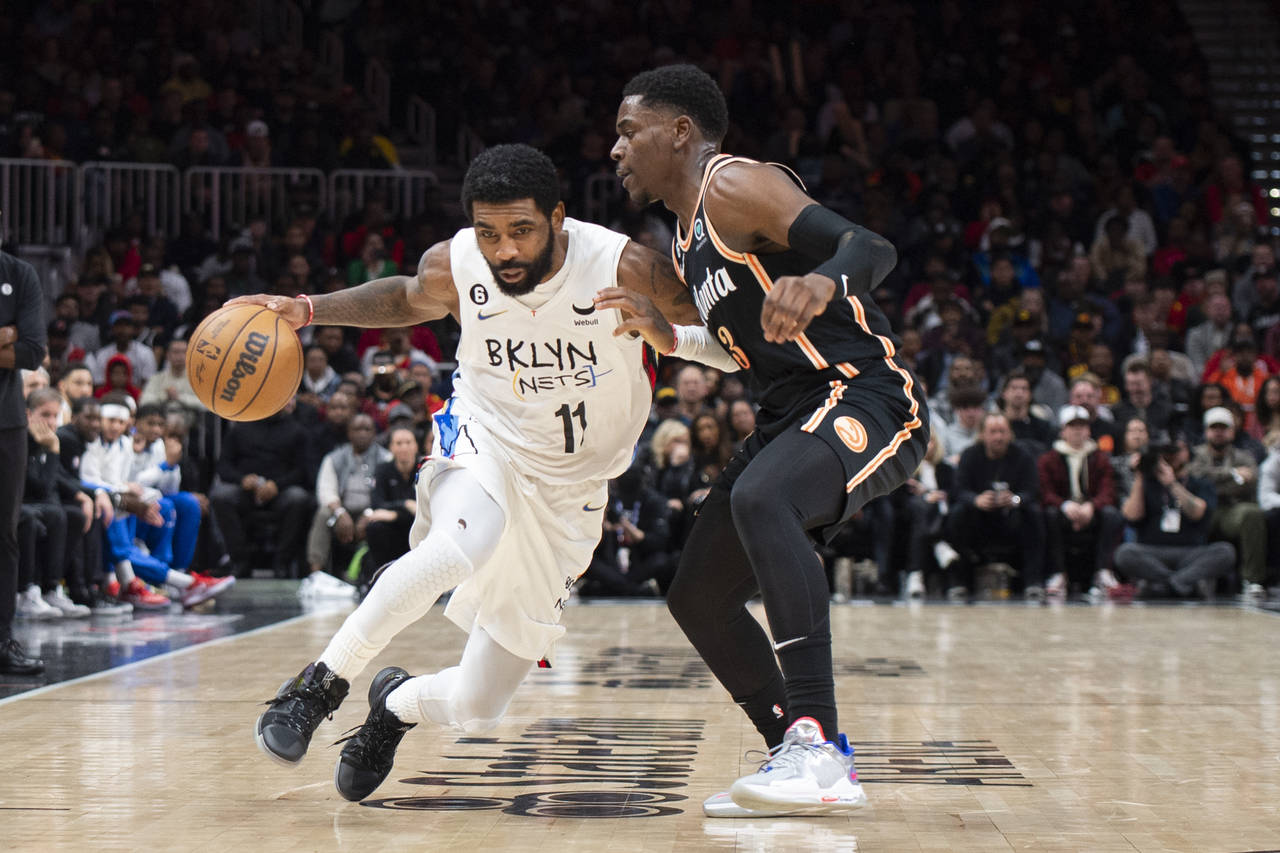 Brooklyn Nets guard Kyrie Irving (11) drives to the basket against Atlanta Hawks guard Aaron Holida...