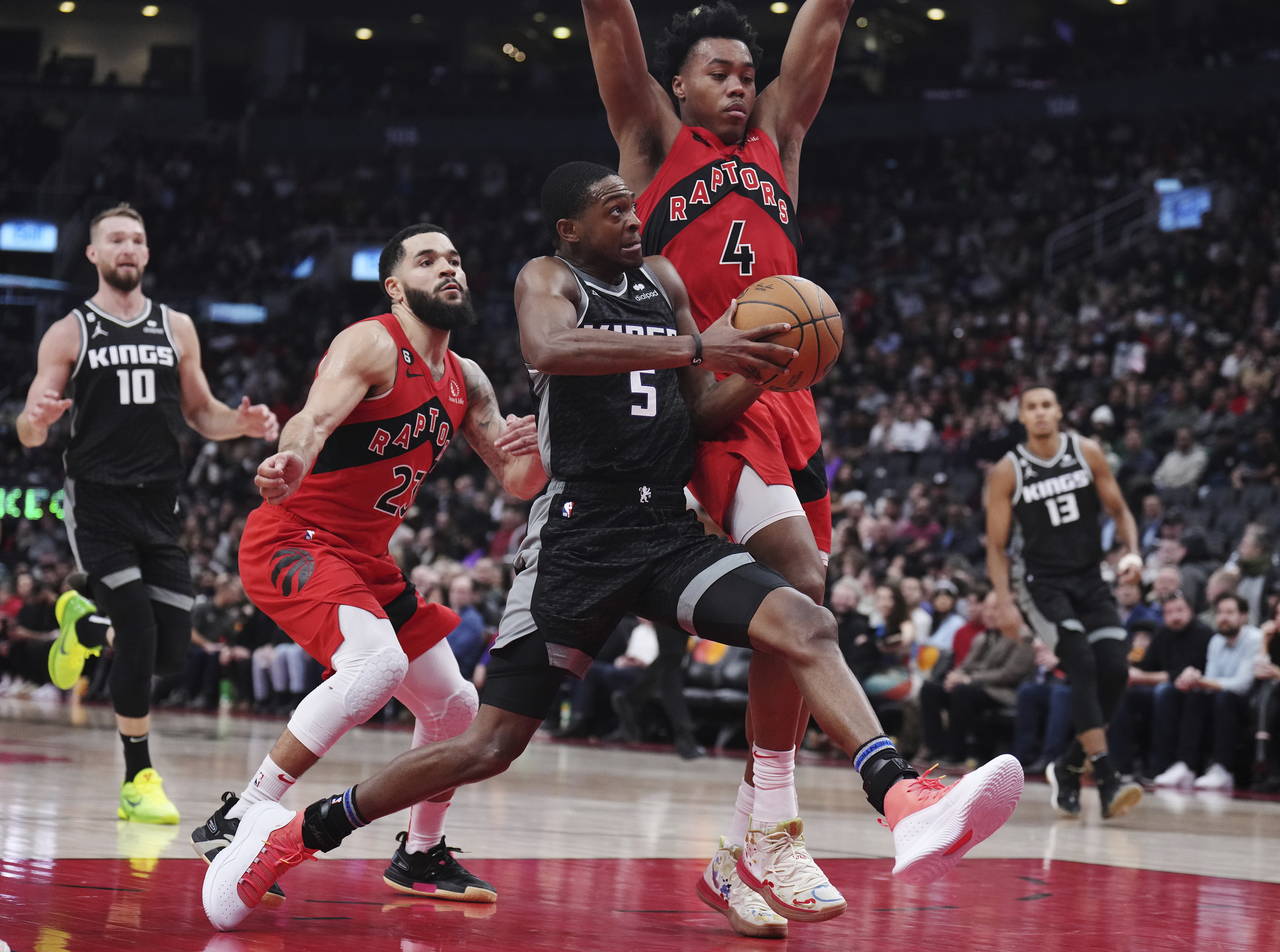 Sacramento Kings guard De'Aaron Fox (5) drives as Toronto Raptors guard Fred VanVleet (23) and forw...