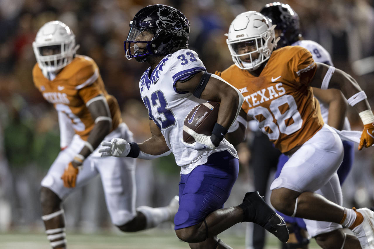 FILE - TCU running back Kendre Miller (33) runs past Texas defensive end Barryn Sorrell (88) during...