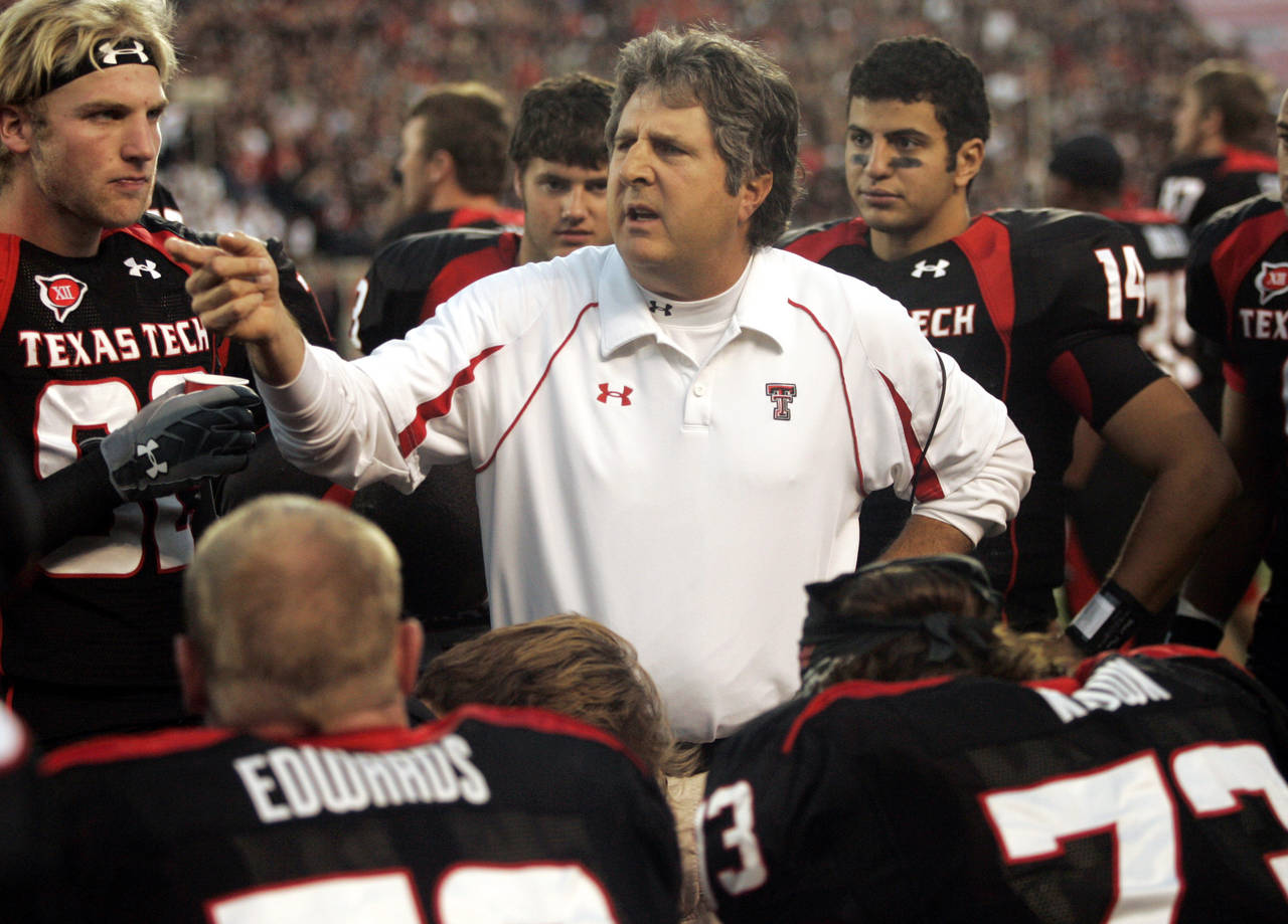 FILE - Texas Tech head coach Mike Leach talks with his team in the second quarter of an NCAA colleg...