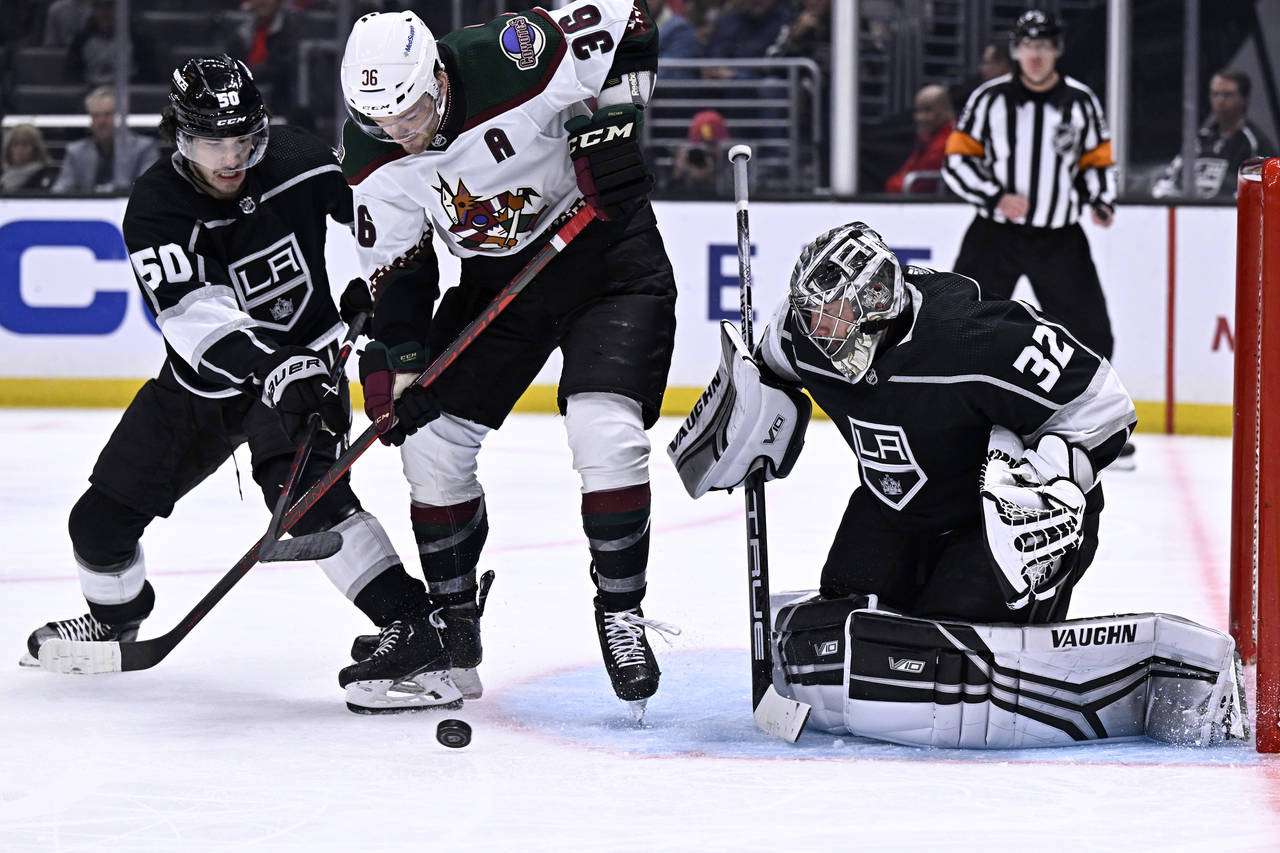 Arizona Coyotes right wing Christian Fischer, center, vies for the puck with Los Angeles Kings defe...