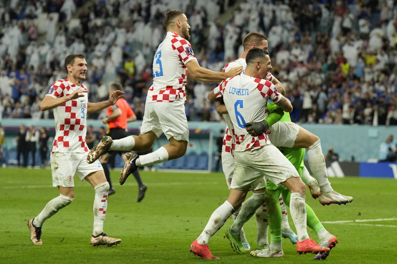 Croatian players celebrate after deafeating Japan during the World Cup round of 16 soccer match bet...