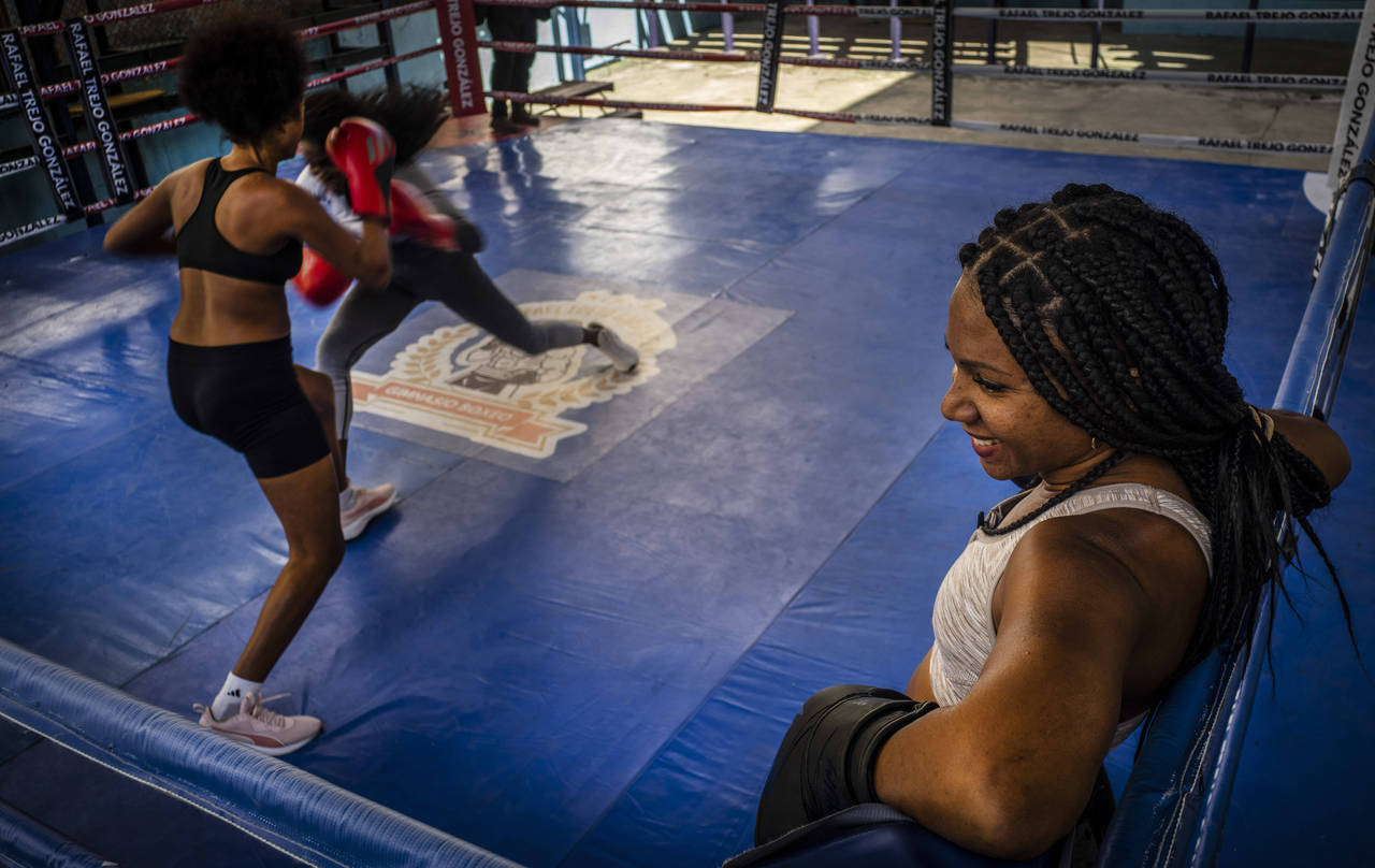 Ydamelys Moreno, right, watches as fellow female boxers train in Havana, Cuba, Monday, Dec. 5, 2022...