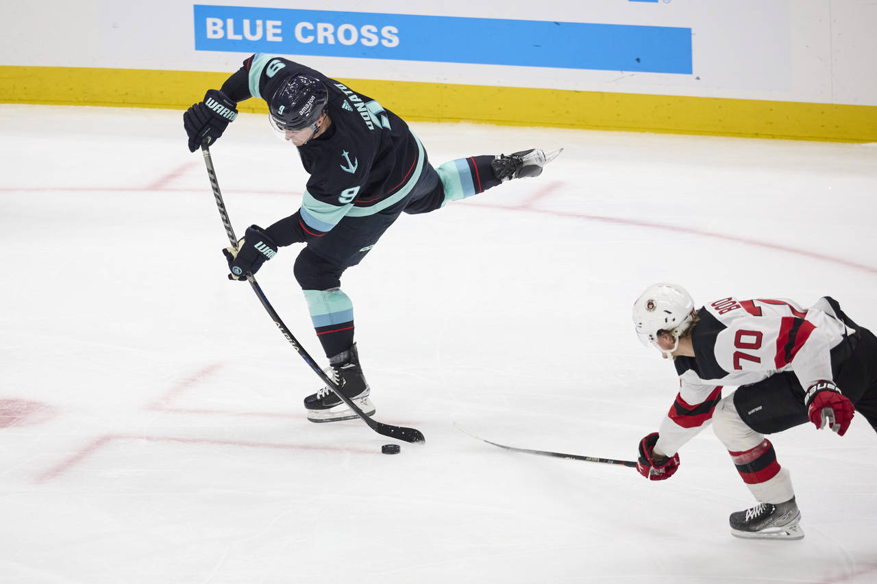 Seattle Kraken center Ryan Donato (9) shoots and scores with New Jersey Devils center Jesper Boqvis...