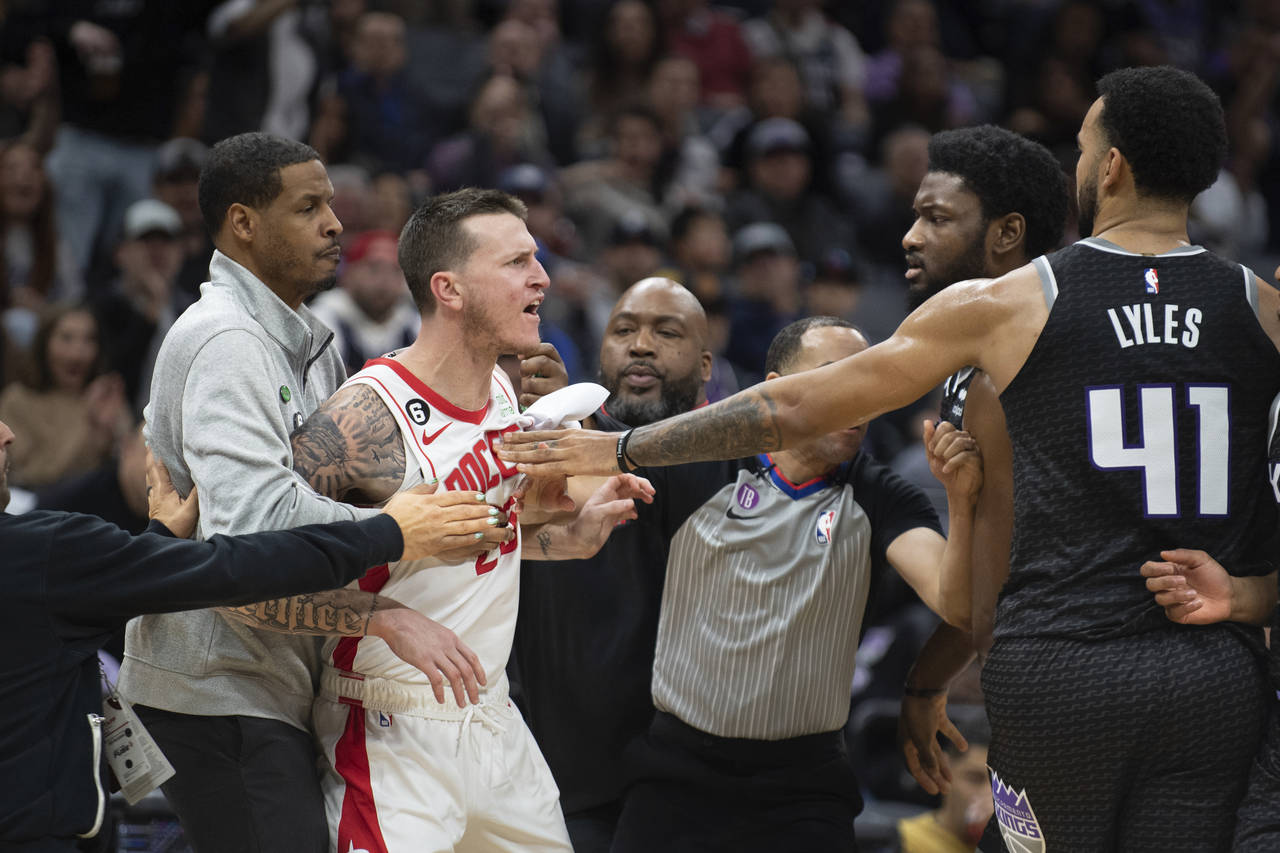 Houston Rockets guard Garrison Mathews (25) is restrained by Rockets coach Stephen Silas as Mathews...
