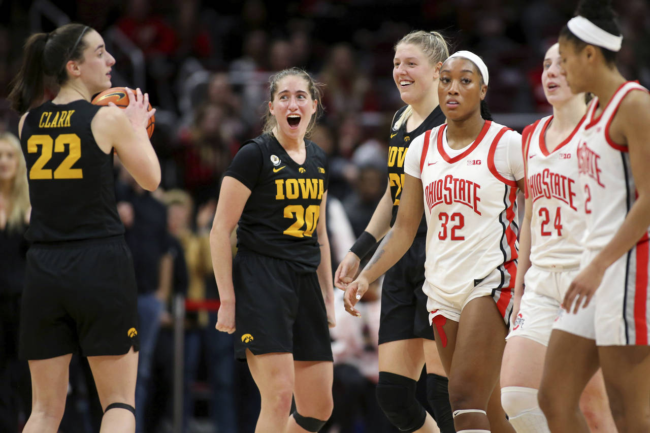 Iowa guard Kate Martin, center, celebrates with forward Monika Czinano, fourth from right, and Cait...