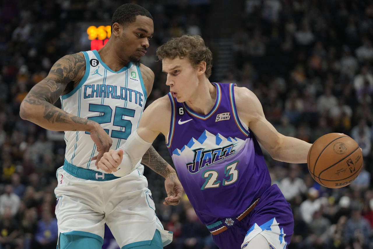 Utah Jazz forward Lauri Markkanen (23) drives around Charlotte Hornets forward P.J. Washington (25)...