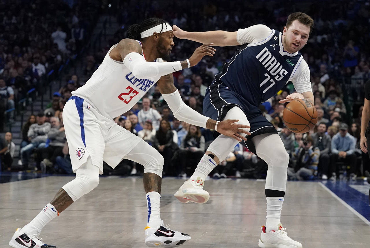 Dallas Mavericks guard Luka Doncic (77) loses his balance while dribbling against Los Angeles Clipp...
