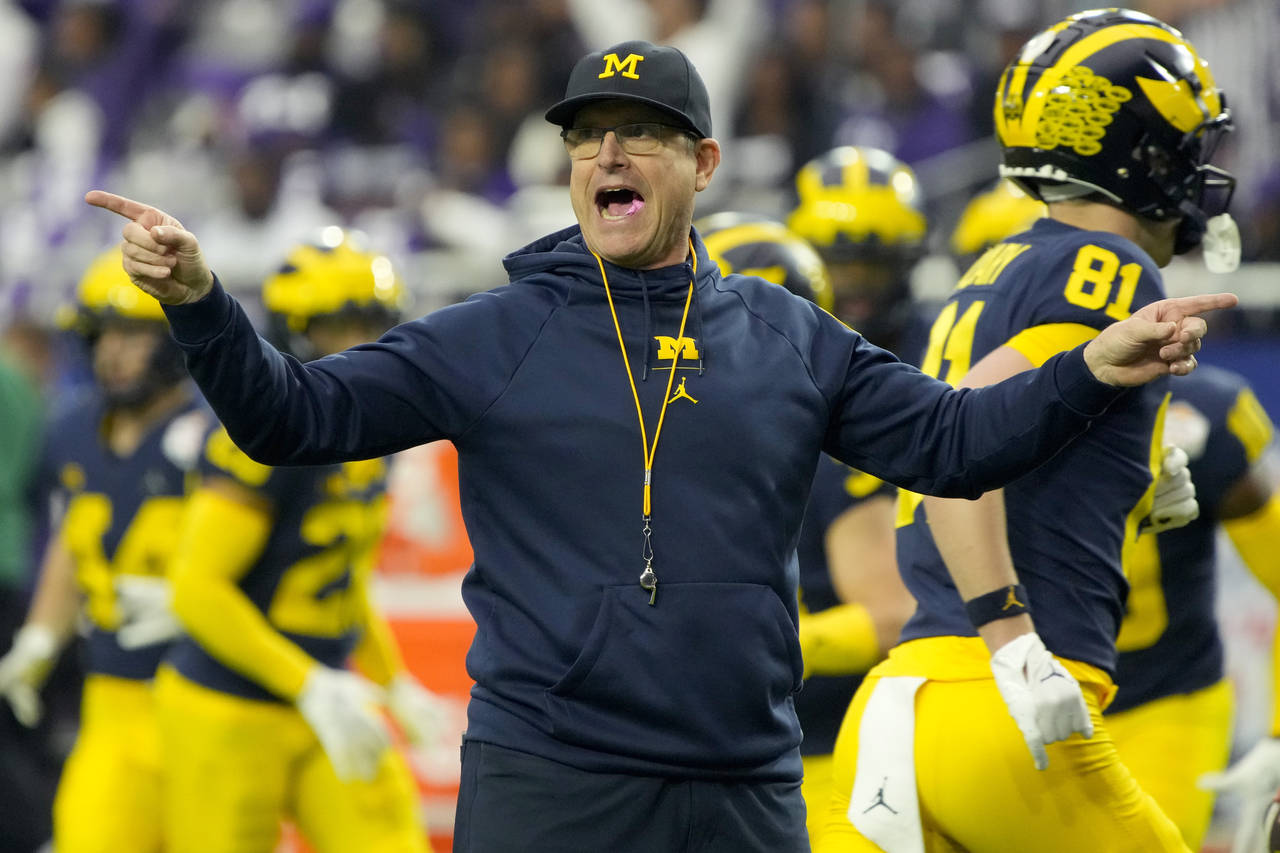 Michigan head coach Jim Harbaugh watches his players prior to the Fiesta Bowl NCAA college football...