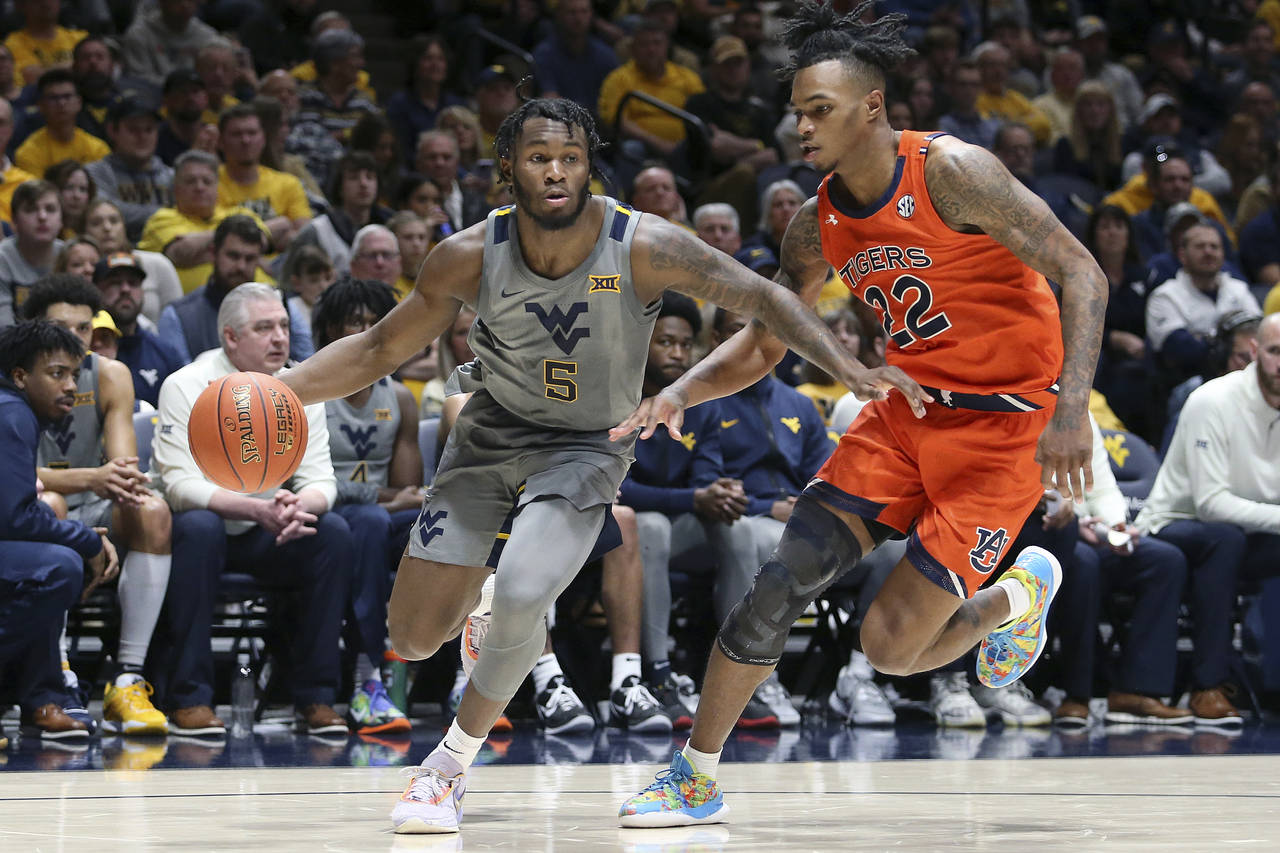 West Virginia guard Joe Toussaint (5) dribbles as Auburn guard Allen Flanigan (22) defends during t...