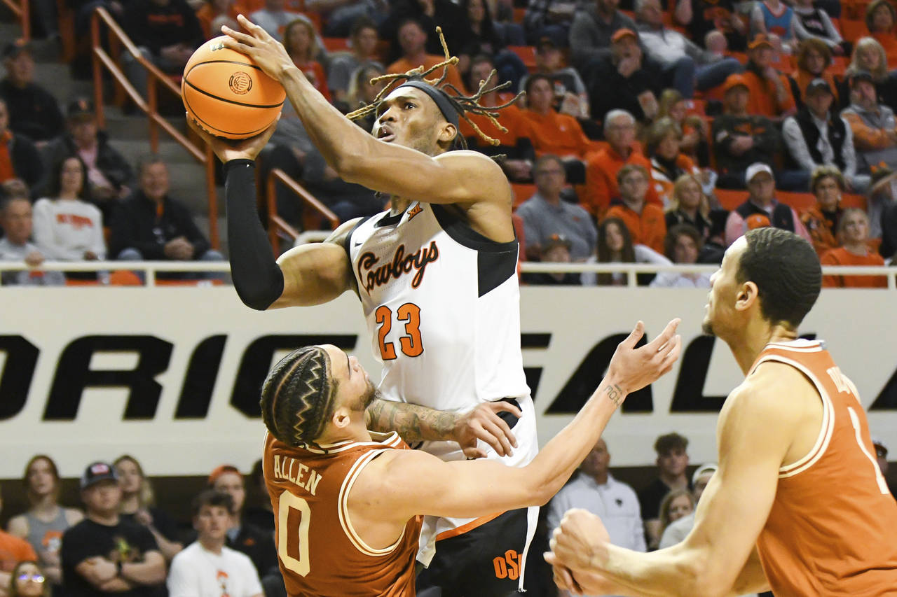 Oklahoma State forward Tyreek Smith (23) takes a shot over Texas forward Timmy Allen (0) while Texa...