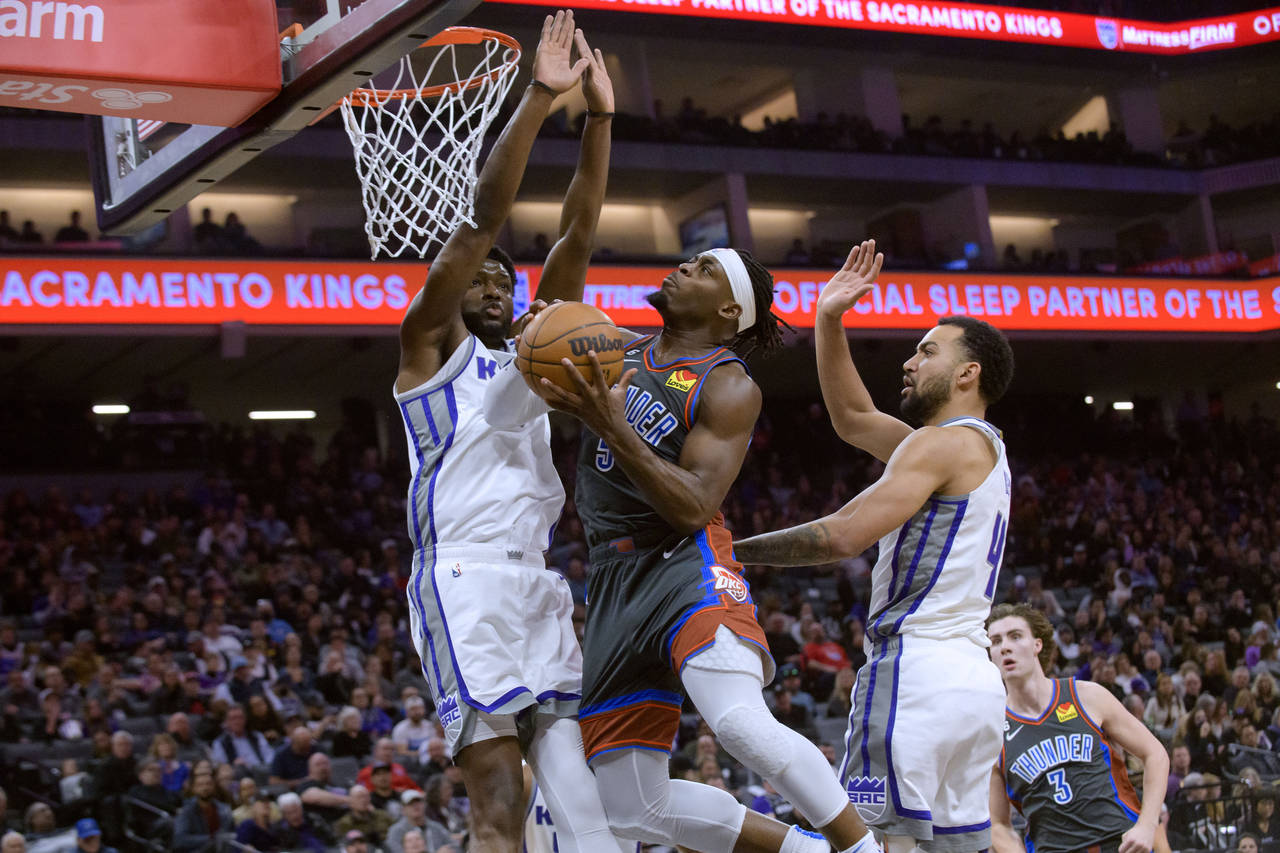 Sacramento Kings forward Chimezie Metu, left, and Oklahoma City Thunder guard Luguentz Dort collide...
