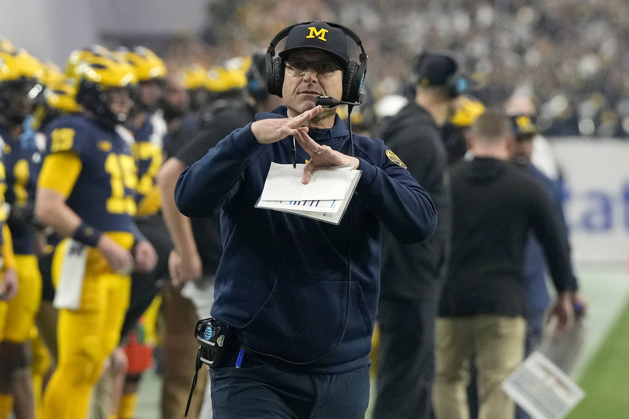 Michigan head coach Jim Harbaugh calls time during the first half of the Fiesta Bowl NCAA college f...