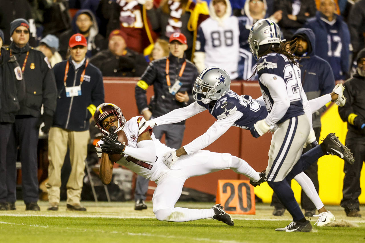 Washington Commanders wide receiver Terry McLaurin, left, hauls in a pass from Sam Howell (not show...