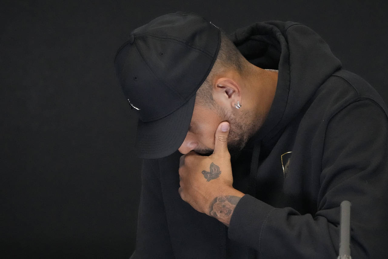 Australia's Nick Kyrgios reacts as he announces his withdrawal from the Australian Open with a knee...