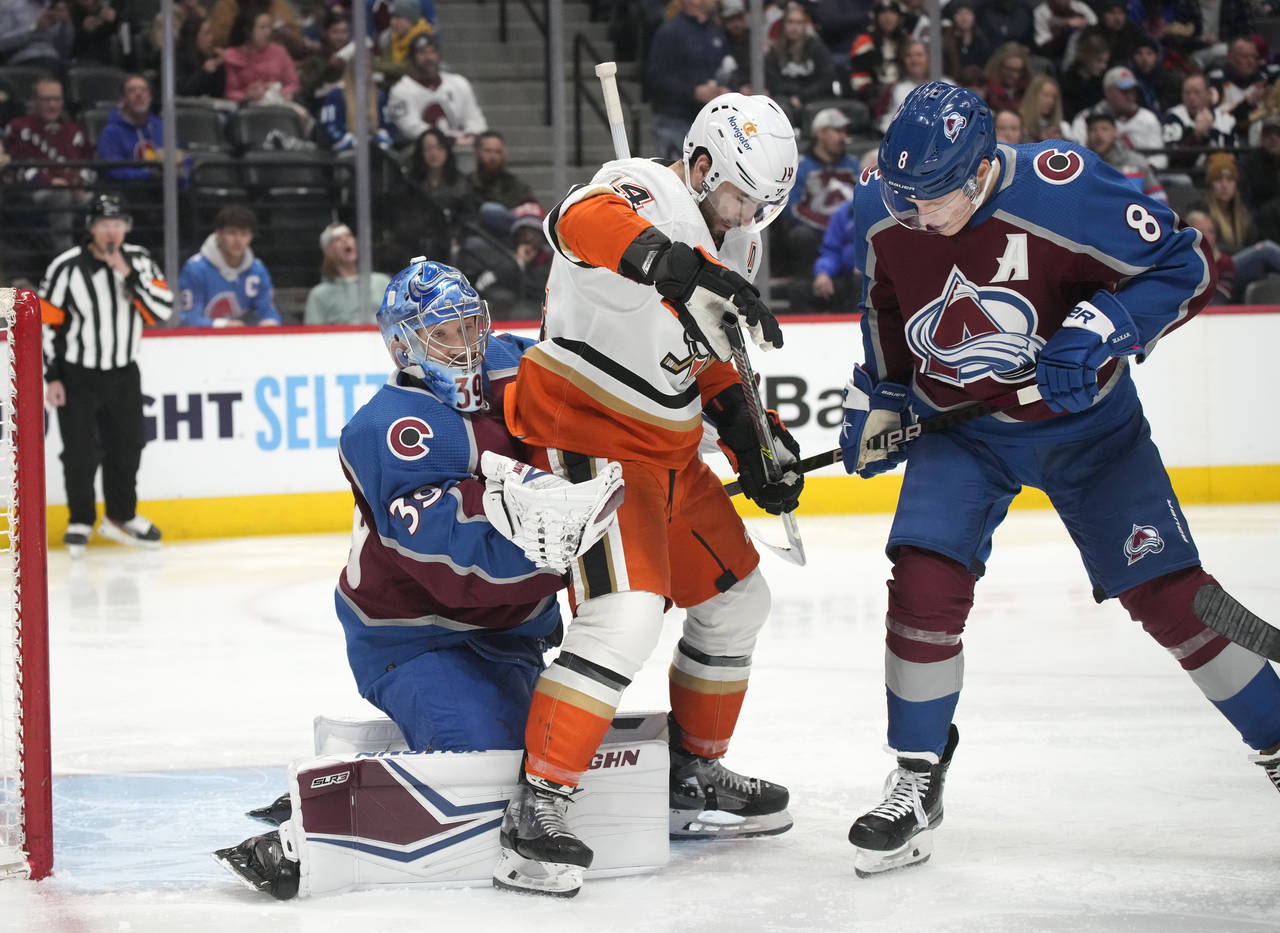 Colorado Avalanche goaltender Pavel Francouz, left, makes a glove save as Anaheim Ducks center Adam...