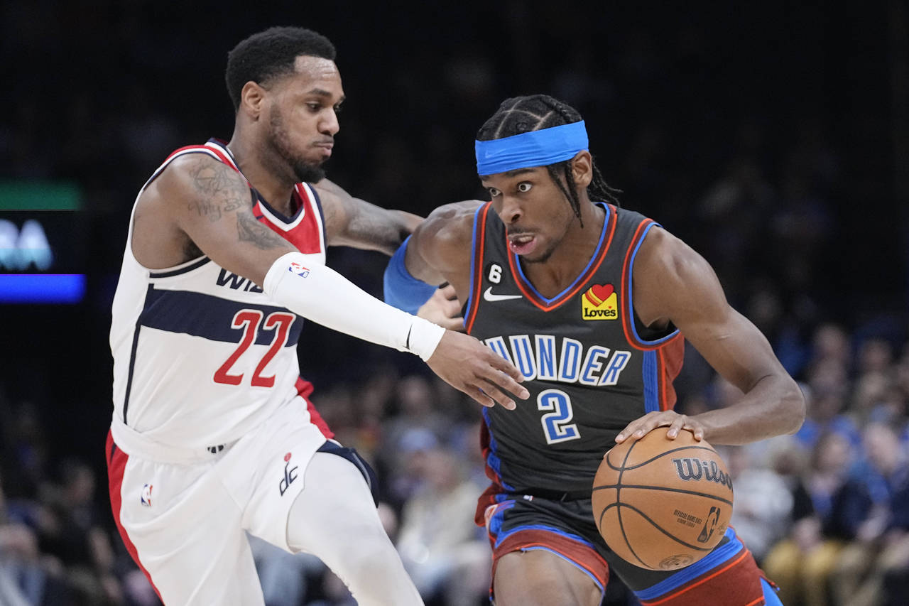 Oklahoma City Thunder guard Shai Gilgeous-Alexander (2) drives around Washington Wizards guard Mont...