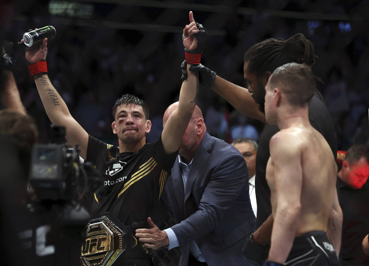 FILE - Brandon Moreno raises his arms as he is declared the winner in a mixed martial arts interim ...
