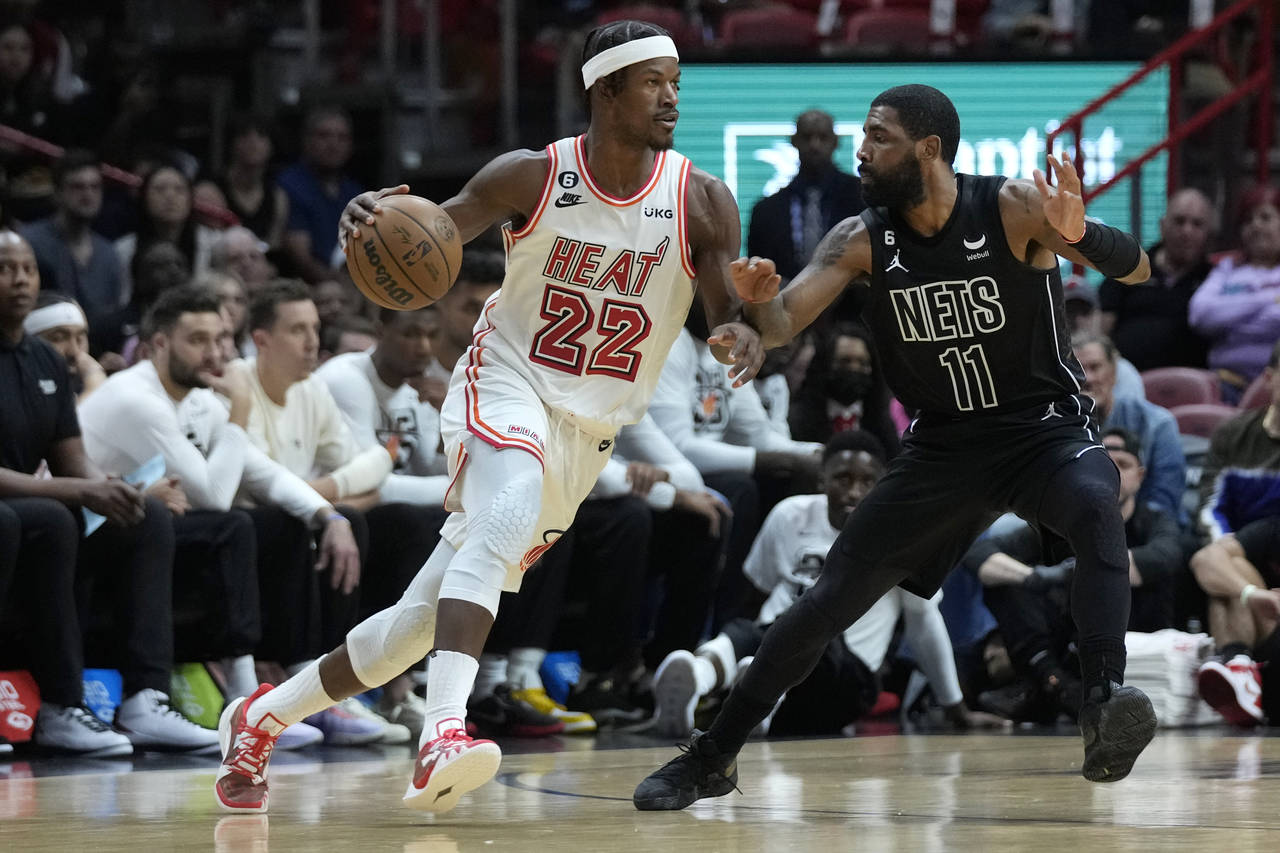 Miami Heat forward Jimmy Butler (22) drives up against Brooklyn Nets guard Kyrie Irving (11) during...