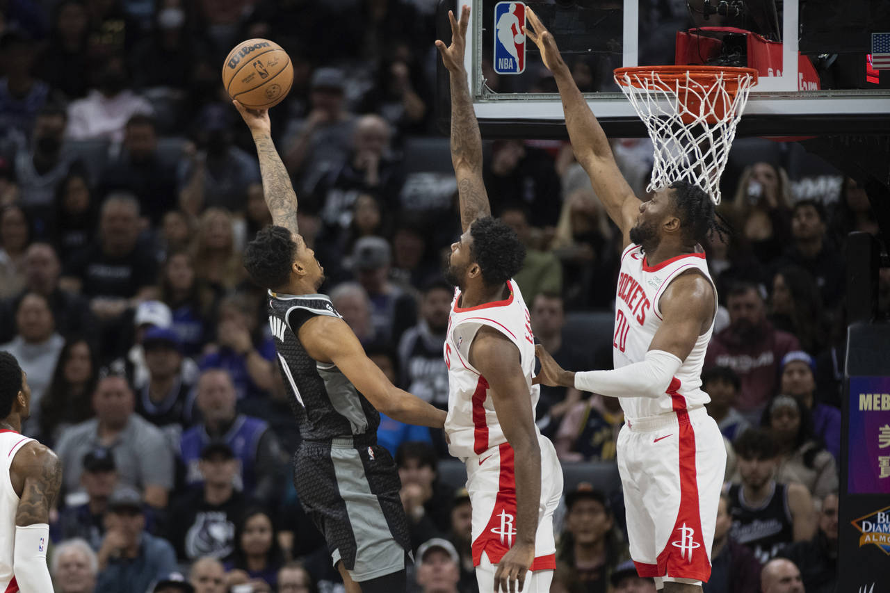 Houston Rockets forward Tari Eason, center, and forward Bruno Fernando (20) defend against Sacramen...