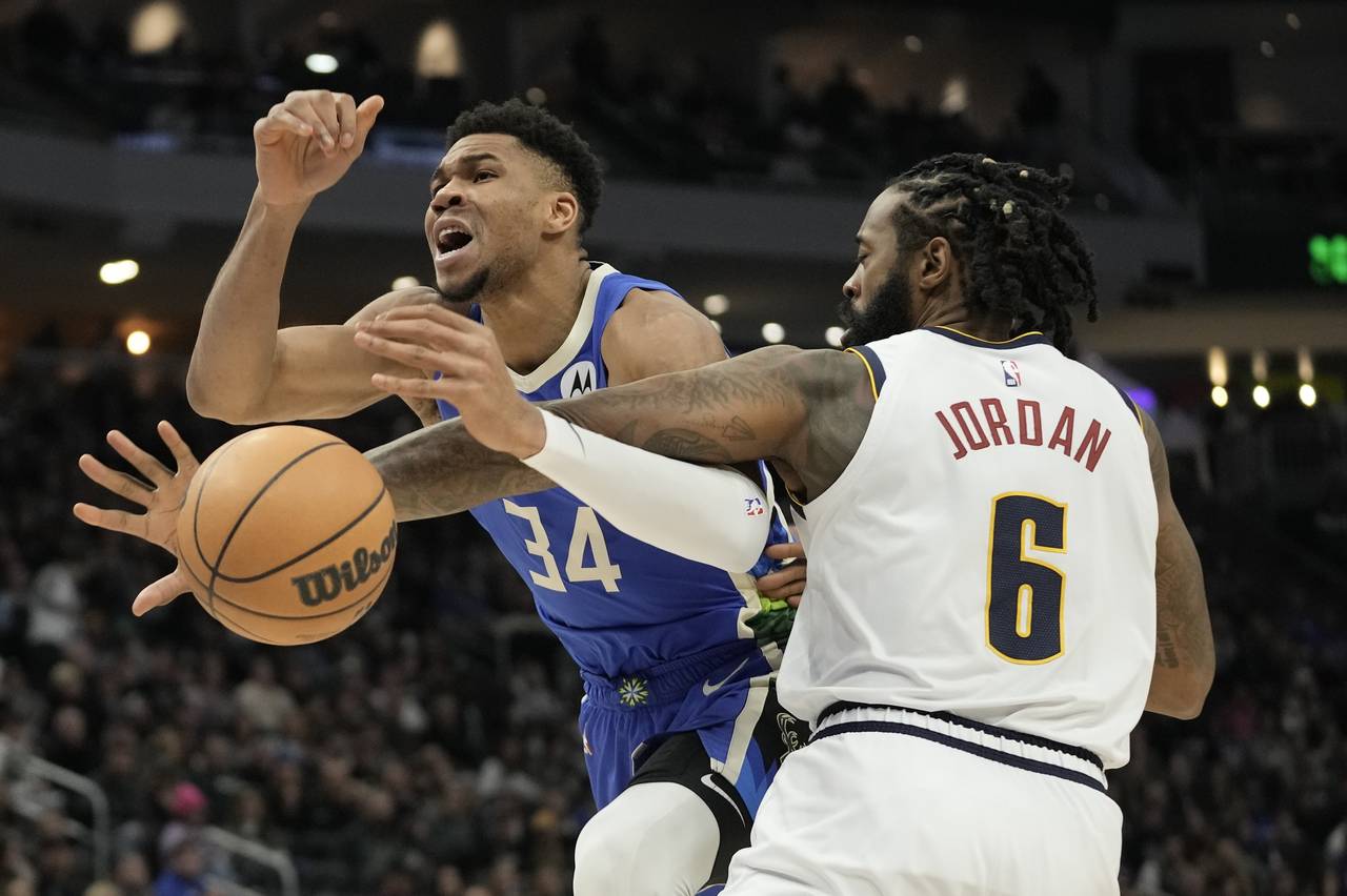DeAndre Jordan fouls Milwaukee Bucks' Giannis Antetokounmpo tduring the second half of an NBA baske...