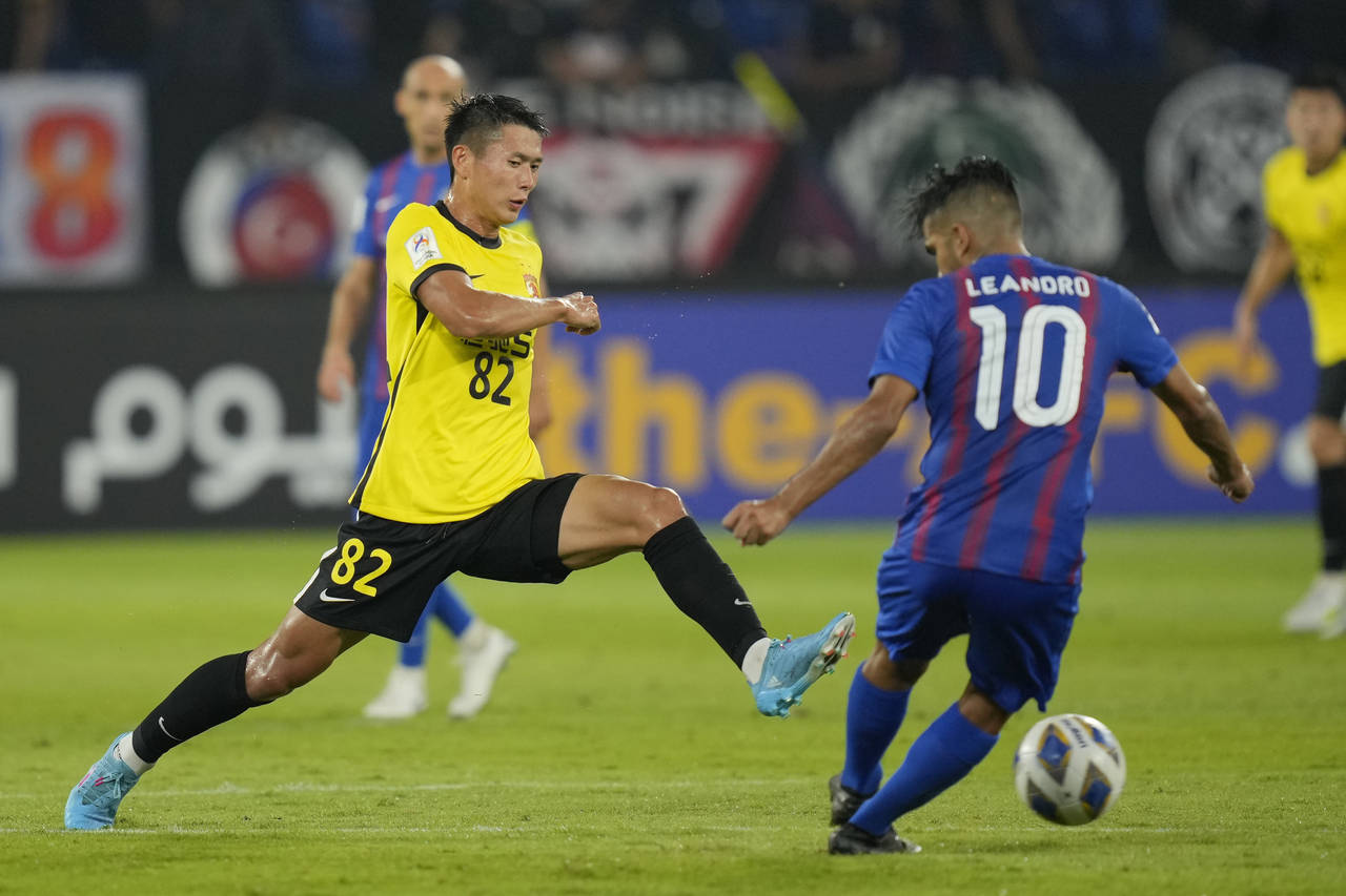 FILE - Huang Kaizho of Guangzhou Evergrande, left, fights for the ball against Leandro Velazquez of...