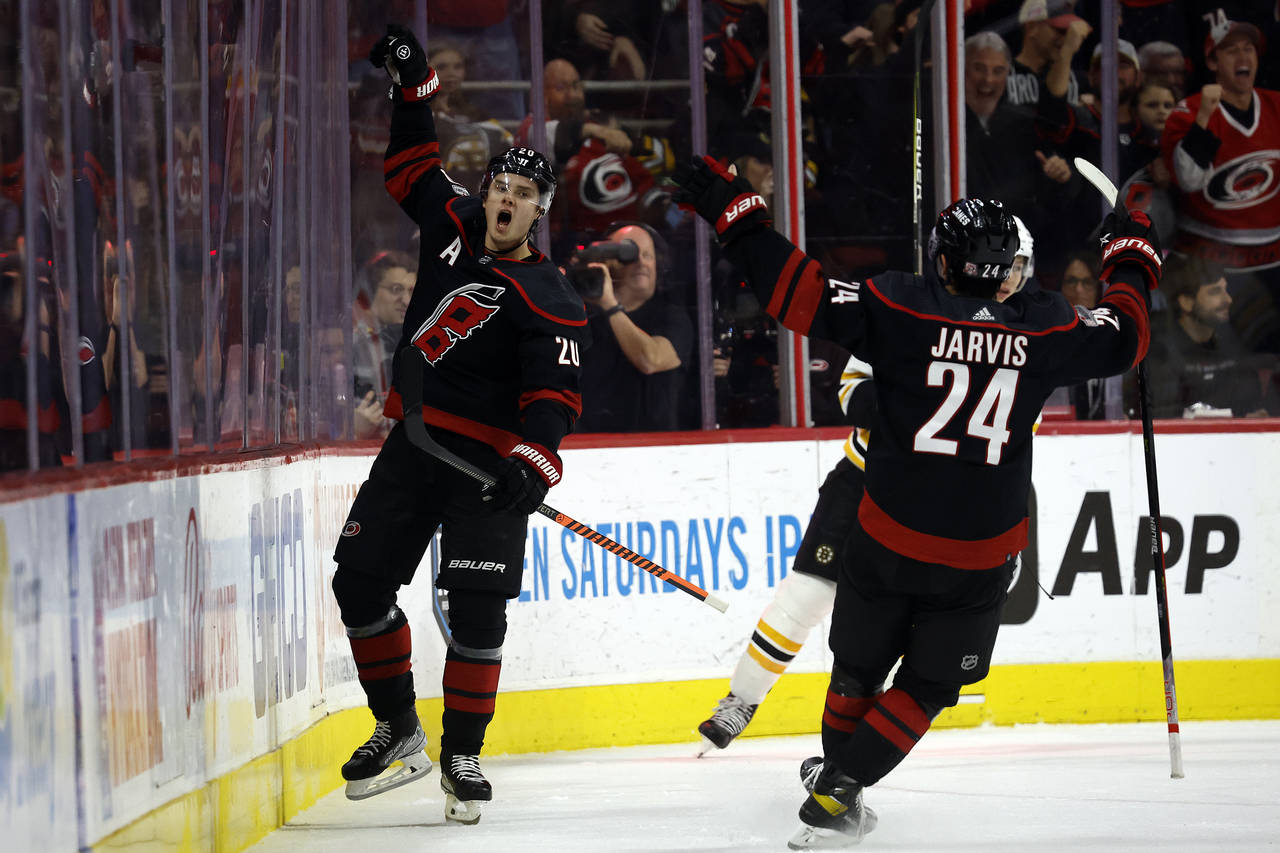Carolina Hurricanes' Sebastian Aho (20) celebrates with teammate Seth Jarvis (24) after scoring dur...