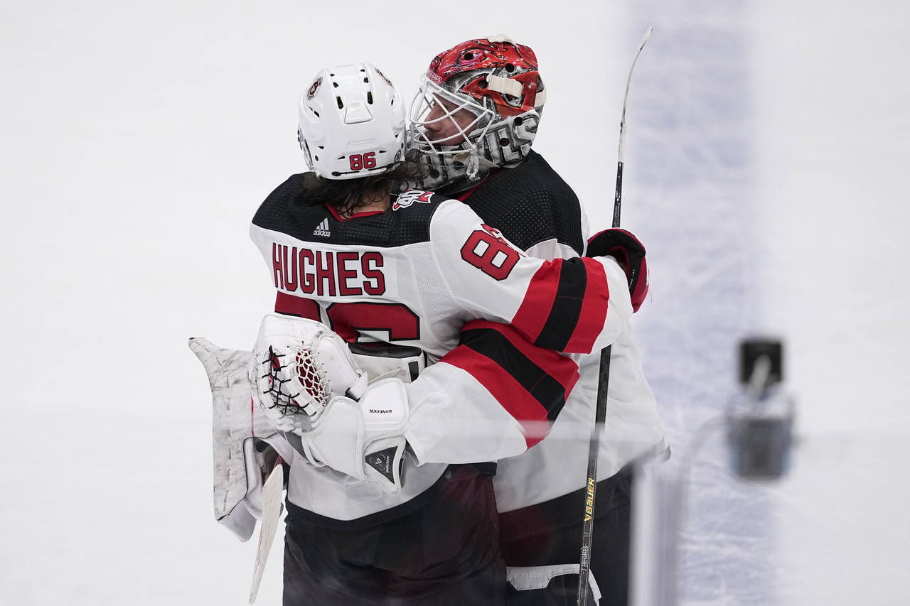 New Jersey Devils' Jack Hughes and Vitek Vanecek (41) celebrate after Hughes scored in overtime of ...