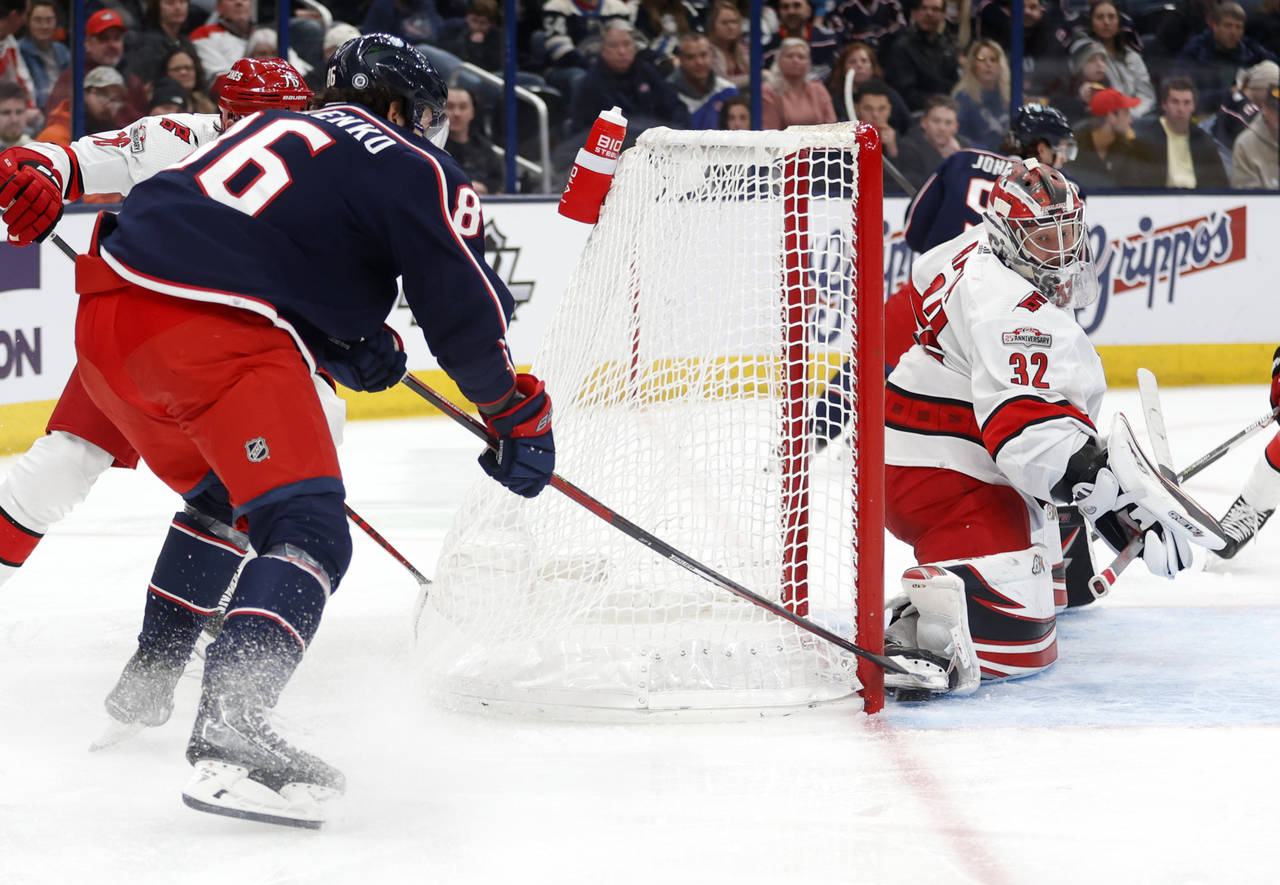 Columbus Blue Jackets forward Kirill Marchenko, left, scores behind Carolina Hurricanes goalie Antt...