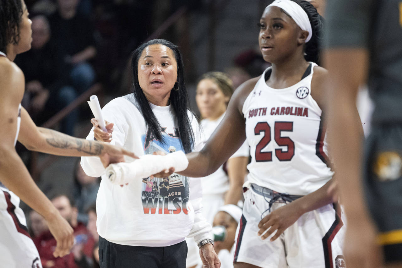 South Carolina head coach Dawn Staley communicates with players as South Carolina guard Raven Johns...